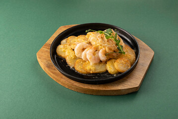 Delicious seafood dish featuring succulent shrimp served on a sizzling plate with crispy potatoes and garnished with fresh herbs, showcasing vibrant colors and appetizing presentation