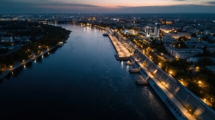 Naklejka premium Aerial View of a Soviet Style Dam at Dusk with City Lights