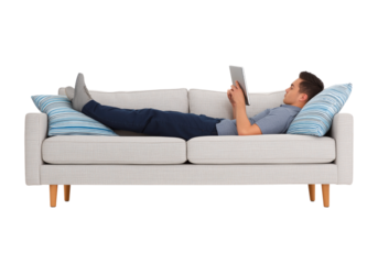 Relaxed Young Man Lounging on Sofa, Engaged with Digital Tablet isolated on a transparent background