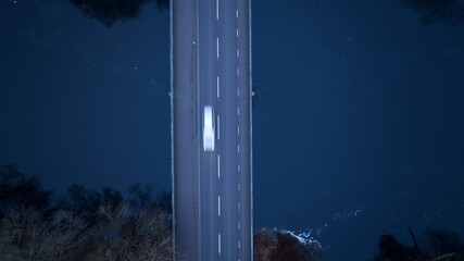 Directly above shot of car moving on highway bridge above water