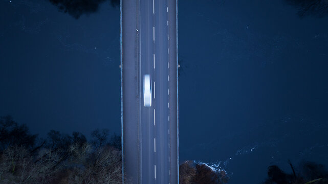 Directly above shot of car moving on highway bridge above water