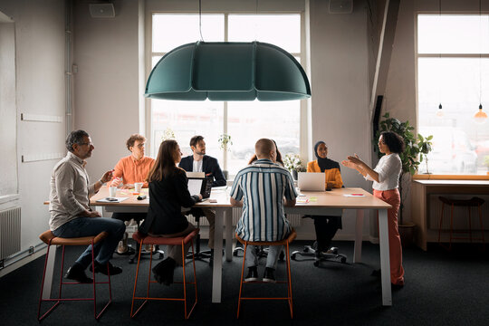 Female business expert discussing strategies with employees in office