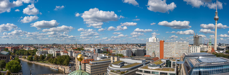 Panoramic view of Berlin with the Fernsehturm and Spree under a sky full of clouds. Modern and...