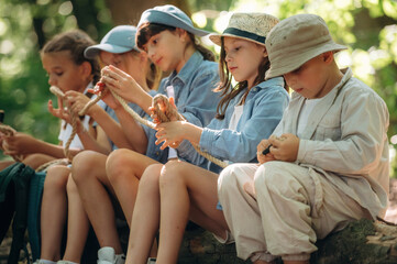 Holding the rope, sitting. Group of children in the forest on a hike