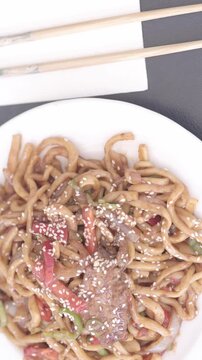 Traditional Uighur Laghman Noodles with Vegetables and Meat on a Rustic Table	