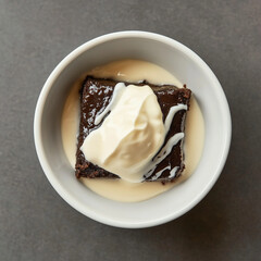 Mammi with cream and custard sauce in simple bowl on dark background