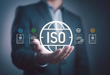 Businessman holding ISO certificate icon with check mark on document, symbolizing international standards, quality assurance, compliance, business certification, organizational process improvement.