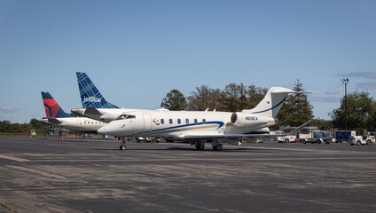 Private jet and commercial airplanes at airport.
