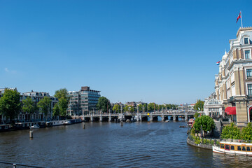 Naklejka premium Beautiful cityscape view of the city of Amsterdam as seen from the canal and bridges.