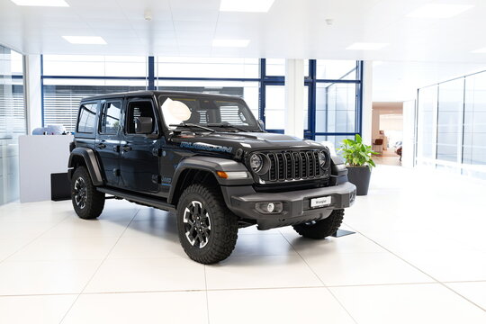 Safenwil, Switzerland, August 16, 2025. Jeep Wrangler Rubicon 4 door SUV. Emil Frey open days showroom floor, wide angle view, window light