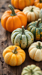 Close-up of rustic pumpkins on wooden table with straw and hay
