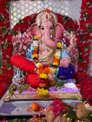 idol of Lord Ganesha, likely in a home or public pandal, adorned with flowers and offerings, signifying the celebration of Ganesh Chaturthi. 