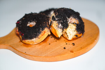 Three chocolate donuts with oreo topping on a wooden stand