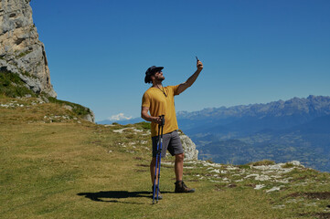 Hiker taking selfie with Mont Blanc and French Alps panoramic view during summer hike