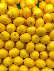 A vibrant, full-frame background of fresh yellow lemons piled high, representing natural health, zesty flavor, and organic abundance