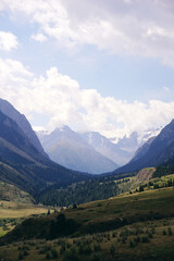 a mountain valley with snow-capped peaks and green meadows in Kyrgyzstan, Tien Shan