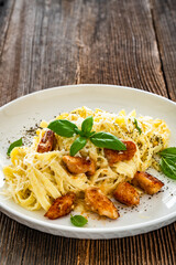 Classic creamy chicken alfredo fettuccine pasta on wooden table	