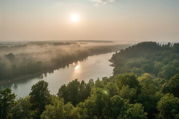 Breathtaking sunrise over a serene mountain lake enveloped in morning fog. Summer morning tranquility in a lush natural setting.