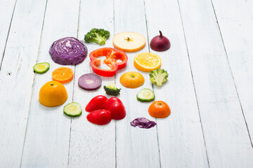 sliced fruit and vegetable circles on white wood table