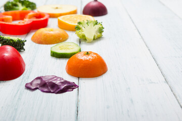 sliced fruit and vegetable circles on white wood table