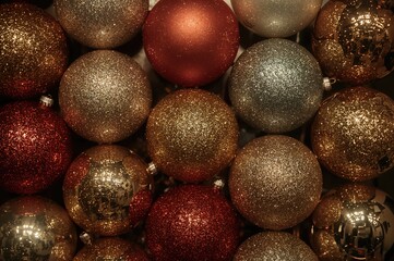 Sophisticated Assortment of Sparkling Festive Ornaments Showcasing Various Hues and Surfaces for Seasonal Decoration and Celebration Settings in Low Light