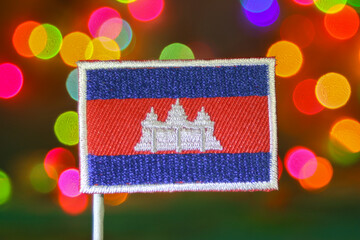 Embroidered Cambodia flag with colorful rainbow bokeh lights glowing like fireworks. Perfect for New Year, holiday, or national day celebration themes.