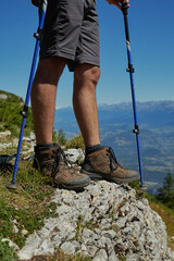 Hiking boots on rocky alpine cliff overlooking Vercors Massif in French Alps