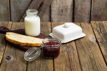 breakfast, cherry jam, milk bottle, slice of bread, old wood table
