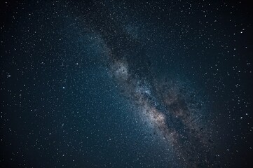 Long-exposure photograph of the Milky Way against a star-filled night sky with visible grain