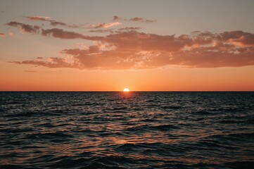 Obraz premium Evening sky over the ocean, romantic holiday sunset with waves