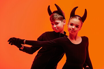 Children skaters dressed as devils perform on ice for Halloween