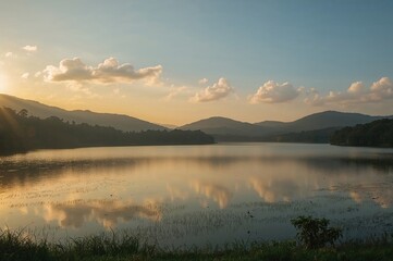 Fototapeta premium Golden sunrise casting light over tranquil lake and fog-covered hills, perfect for scenic and travel photography.