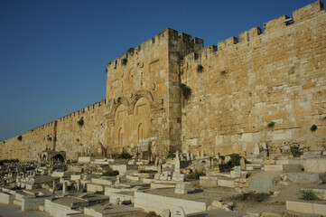 The medieval stone walls and ramparts of the Old City of Jerusalem and the cemetery and sealed twin arches of the Mercy Gate or Golden Gate. © Yehoshua Halevi