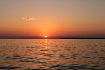 Evening glow over ocean waves with silhouetted horizon