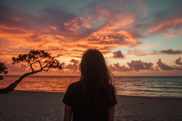 Fototapeta premium Female watching the evening sky at a tropical beach.