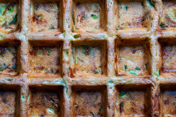 Background and texture of zucchini and herbs waffle made with waffle maker, closeup, top view....
