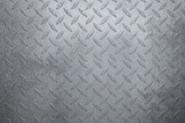 The metal plate's intricate silver design introduces a contemporary and striking texture to the background wall, resembling a sophisticated steel wallpaper.