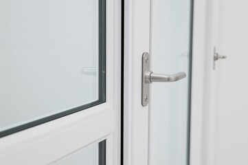 Fototapeta premium Close-up of white PVC window frame with hardware components.
