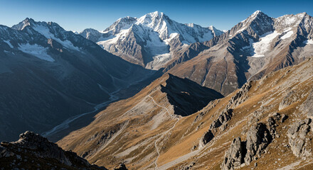 Majestic snow-capped mountain range with winding valley and clear blue sky
