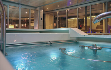 Modern design inside thermal suite relaxation spa wellness area on luxury cruiseship cruise ship liner with showers, loungers tranquility and indoor swimmingpool