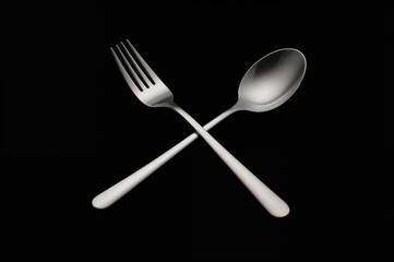 Fork and spoon made of stainless steel on a dark background