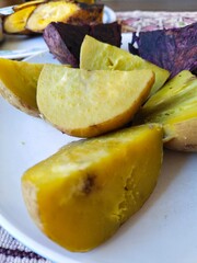 Steamed white sweet potatoes, steamed purple sweet potatoes, and steamed bananas are served as a snack with a cup of coffee or a cup of tea