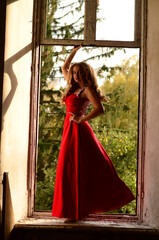 Beautiful modern girl in rad dress near the brickwall. Youth style. Fashion shot.
