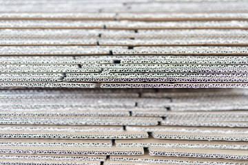 High-resolution image of stacked corrugated cardboard sheets, ideal for packaging, industrial, and texture backgrounds.  Provides a detailed close-up view.
