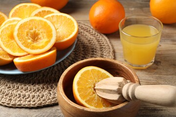 Freshly squeezed orange juice, fruits and juicer on wooden table, closeup