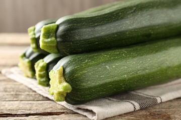 Fresh ripe zucchinis on wooden table, closeup