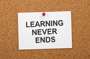 Continuous Learning Message on White Paper Attached to Corkboard - Professional Theme