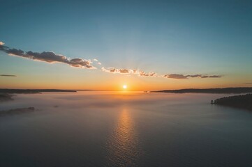 Fototapeta premium Early dawn with foggy landscape enhancing the lake's charm