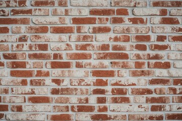 Naklejka premium Vintage textured wall with red bricks and light gray stucco, featuring an aged stonework pattern in a home interior setting