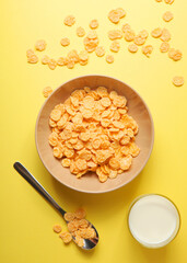 Crispy cornflakes with milk for breakfast on a colored background close-up.. Vertical photo format